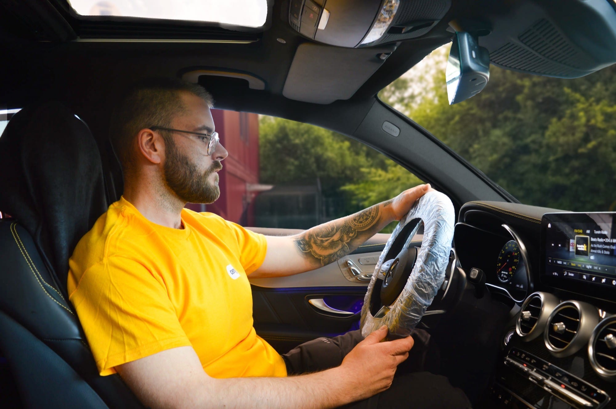 cenya. Fahrer am Steuer des abgeholten Kundenfahrzeugs auf dem Weg zur Werkstatt